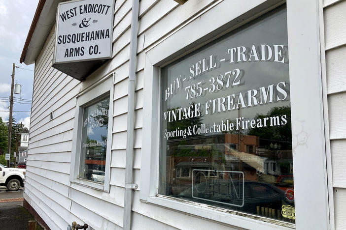 A rifle hangs on display in the window of the West Endicott & Susquehanna Arms Co., where Payton Gendron purchased firearms in Endicott, N.Y.
