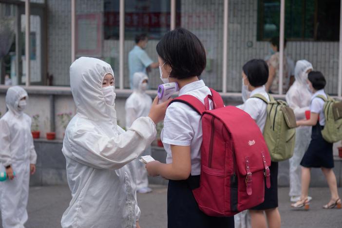 Students of the Pyongyang Jang Chol Gu University of Commerce in North Korea undergo temperature checks before entering the campus. The country said there were no cases — until May 12.