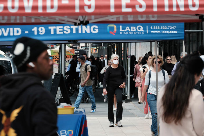 People walk past a COVID testing site on May 17 in New York City. New York's health commissioner, Dr. Ashwin Vasan, has moved from a "medium" COVID-19 alert level to a "high" alert level in all the five boroughs following a surge in cases.