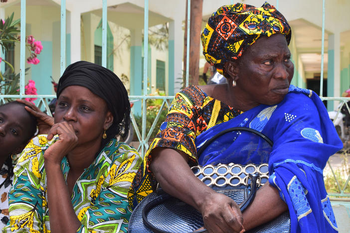 Relatives sit outside the Abdoul Aziz Sy Dabakh Hospital in Tivaouane, Senegal, a town 75 miles northeast of Dakar Thursday, May 26, 2022.