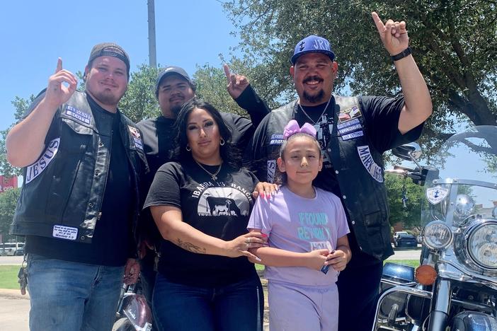 Celeste Ibarra and her daughter, Aubriella Melchor, who survived the mass shooting on Tuesday, prayed with members of the Journey Riders, Sons of God Motorcycle Club, including Adam Torres (far left) at Murphy USA gas station in Uvalde, Texas.