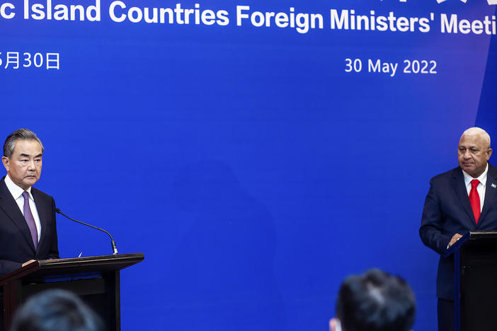 China's Foreign Minister Wang Yi, left, appears on stage at the Pacific Islands Foreign Ministers' meeting with Fiji's Prime Minister Frank Bainimarama, Monday, May 30, 2022, in Suva, Fiji.