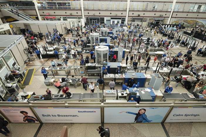Travelers queue up at a security checkpoint in the main terminal of Denver International Airport on Thursday.