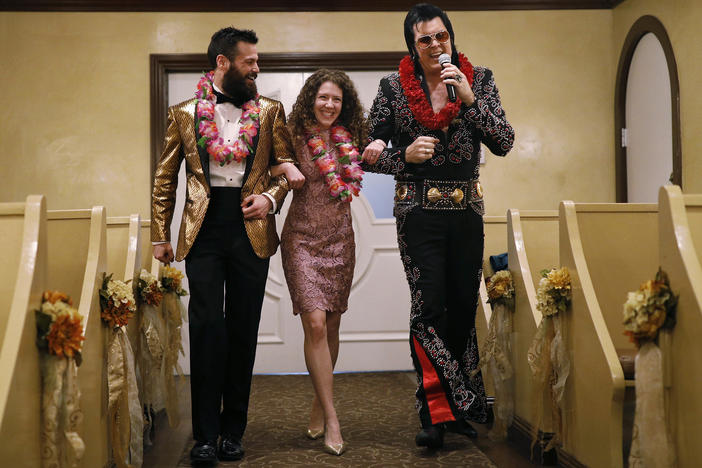 Elvis impersonator Brendan Paul (right) walks down the aisle during a wedding ceremony for Katie Salvatore and Eric Wheeler at the Graceland Wedding Chapel in Las Vegas.
