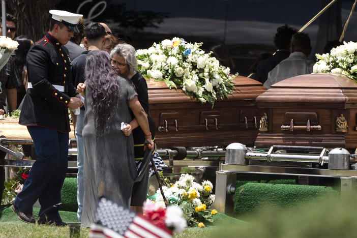 Mourners comfort each other Wednesday during the burial service for Irma Garcia and her husband Joe Garcia at Hillcrest Cemetery in Uvalde, Texas. Irma Garcia was killed in last week's elementary school shooting. Joe Garcia died two days later.