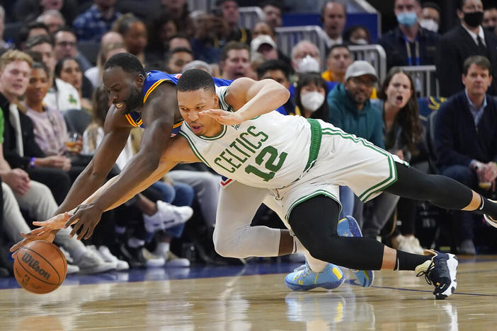 Golden State Warriors forward Draymond Green, left, and Boston Celtics forward Grant Williams reach for the ball March 16 during a regular season game. The two teams will face off in the NBA Finals starting Thursday night.