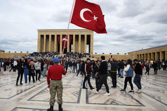 A man stands with a Turkish as flag people visit the mausoleum of Mustafa Kemal Ataturk in Ankara on May 19, the 103rd anniversary of the start of Turkey's War of Independence.