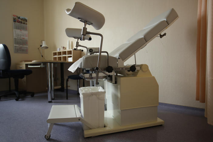 A gynecology chair sits in a doctor's office.