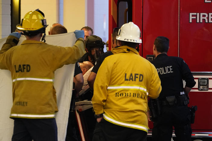 A suspect who stabbed multiple people and barricaded himself inside the Encino Hospital Medical Center is transported into a waiting ambulance after being extracted from the hospital in Encino, Calif., late Friday.