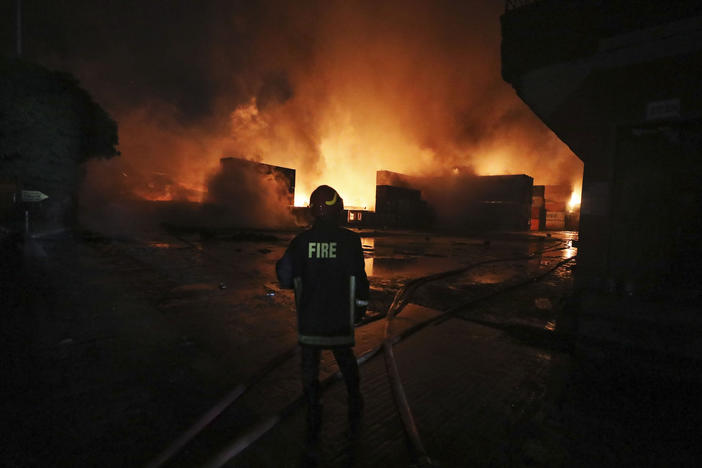A firefighter works to contain a fire that broke out at the BM Inland Container Depot, a Dutch-Bangladesh joint venture, in Chittagong, Bangladesh, early Sunday.