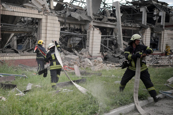 Firefighters continue to dampen a railcar repair facility in Kyiv after a Russian airstrike on Sunday.