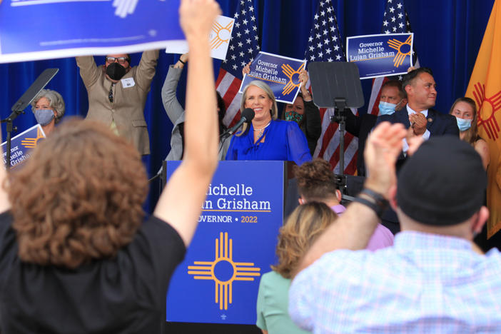 New Mexico's Democratic governor, Michelle Lujan Grisham (center), smiles as supporters cheer during a campaign rally in Albuquerque, N.M., on June 3, 2021. The rally was cut short as protesters chanted loudly beyond the walls of the outdoor venue.