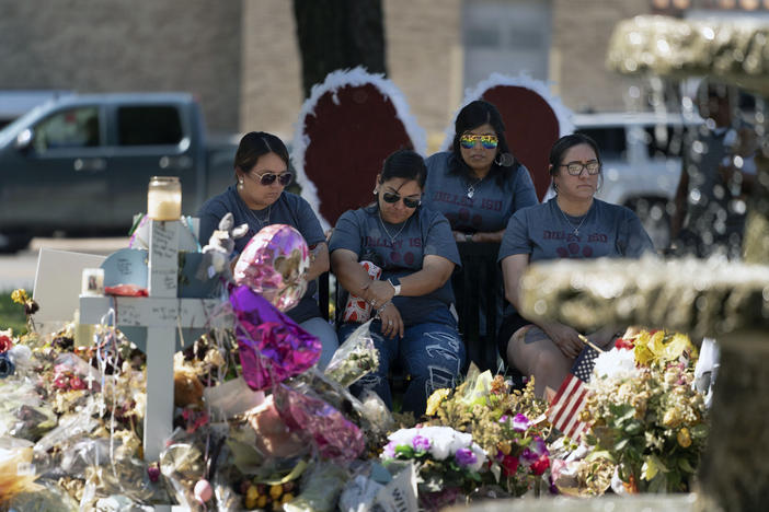 A group of teachers visiting from Dilley, Texas, view a memorial honoring the victims killed in last week's elementary school shooting in Uvalde, Texas, Friday, June 3, 2022.