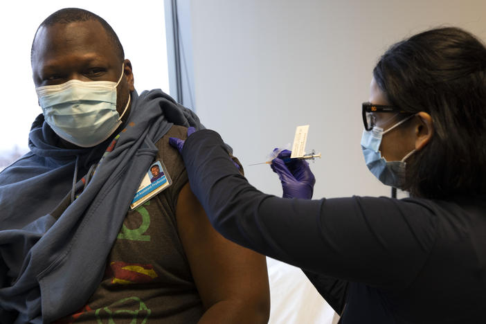 Dr. Stephaun Wallace, who leads the global external relations strategies for the COVID-19 Prevention Network at the Fred Hutchinson Cancer Research Center in Seattle, receives his second injection from Dr. Tia Babu during the Novavax vaccine phase 3 clinical trial in February 2021.