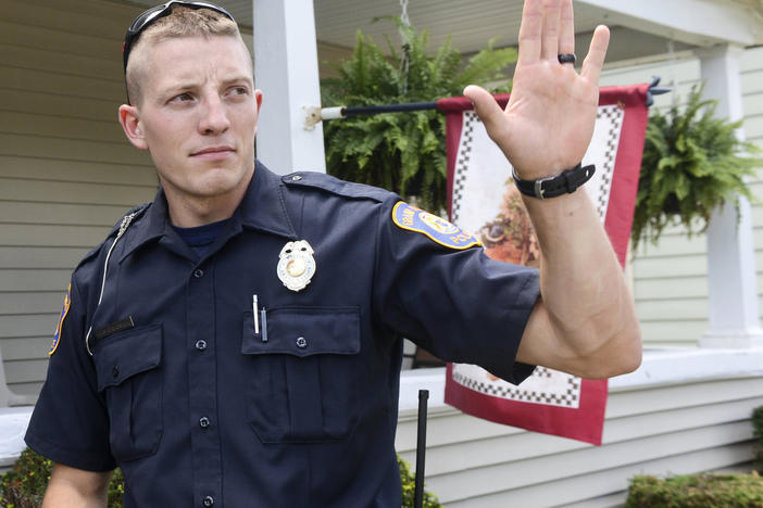 Grand Rapids police officer Christopher Schurr stops to talk with a resident in 2015 in Grand Rapids, Mich.