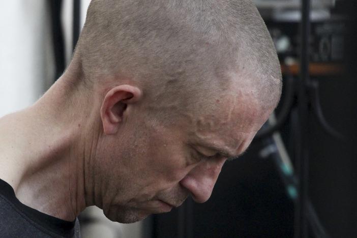 British citizen Shaun Pinner sits behind bars in a courtroom in Donetsk, in the territory which is under the Government of the Donetsk People's Republic control, eastern Ukraine, Thursday, June 9, 2022.