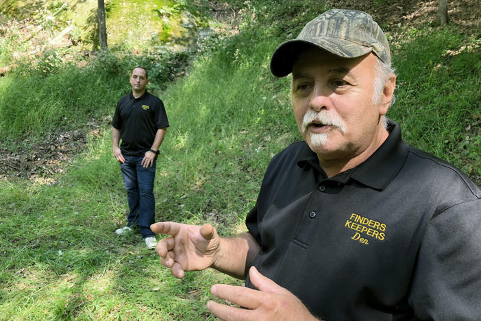 Dennis Parada, right, and his son Kem Parada stand at the site of the FBI's dig for Civil War-era gold in September 2018 in Dents Run, Penn. A scientific report commissioned by the FBI shortly before agents went digging for buried treasure suggested that a huge quantity of gold was below the surface.