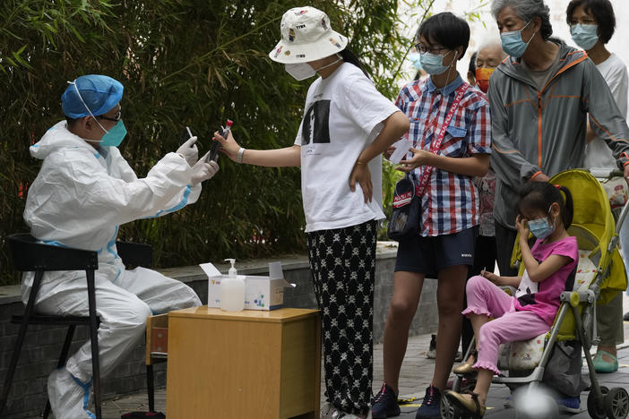 Residents line up for mass COVID tests, Monday, June 13, 2022, in Beijing.