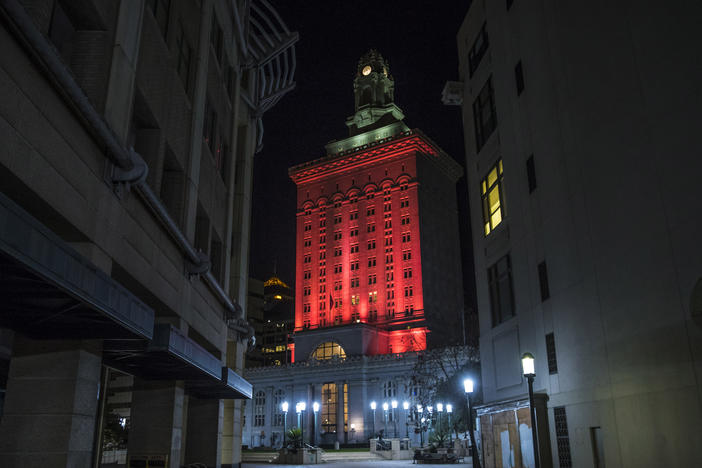 Oakland City Hall is bathed in red light in a memorial to the people who have died from COVID-19 throughout the country in Oakland, Calif. in January 2021.