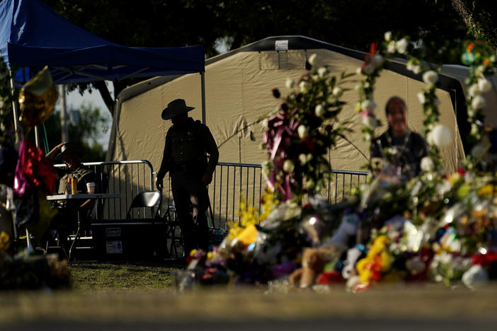A Texas Department of Public Safety officer keeps watch on June 3, 2022, in Uvalde, Texas, near a memorial outside Robb Elementary School.