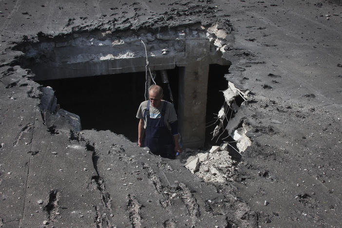 A man examines the roof of a hospital damaged during shelling in Donetsk, eastern Ukraine, on Tuesday.
