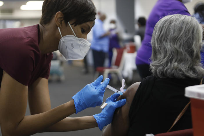 A Black woman receives a COVID-19 vaccine at a clinic in Tampa, Fla. Black Americans have died of the disease at a rate more than double that of white people.