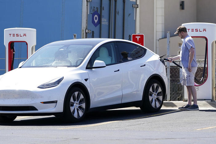 A Tesla owner charges his vehicle in April 2021 at a charging station in Topeka, Kan.. Tesla reported 273 crashes involving partially automated driving systems, according to statistics released by U.S. safety regulators on Wednesday.