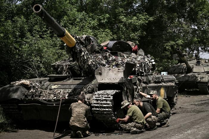 Ukrainian troops repair an army tank in Ukraine's eastern Donbas region on June 7. Ukrainians have been urging the U.S. and its allies to supply them more weapons in their fight against Russia, and Gen. Mark Milley, President Biden's top military adviser, told NPR that Russia has massed greater numbers of combat units, as well as more artillery, than the local defenders in the Donbas have.