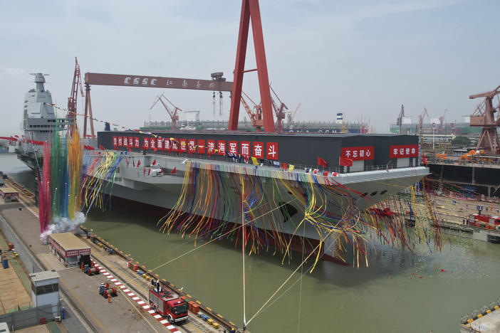 In this photo released by Xinhua News Agency, colored smoke mark the launch ceremony for China's third aircraft carrier christened Fujian at a dry dock in Shanghai on Friday, June 17, 2022.