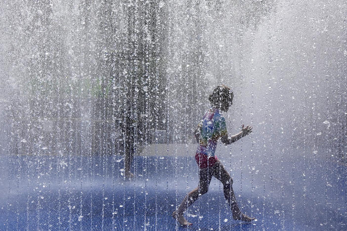 A child plays in a fountain in the warm weather in London, Friday, June 17, 2022. A blanket of hot air stretching from the Mediterranean to the North Sea is giving much of western Europe its first heat wave of the summer, with temperatures forecast to top 30 degrees Celsius (86 degrees Fahrenheit) from Malaga to London on Friday.