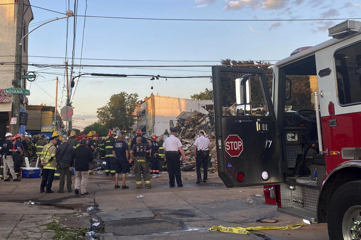 Emergency personnel respond to the scene of a building that caught fire then collapsed early Saturday in Philadelphia. The Philadelphia Fire Department said several firefighters and a city inspector became trapped when the building collapsed.