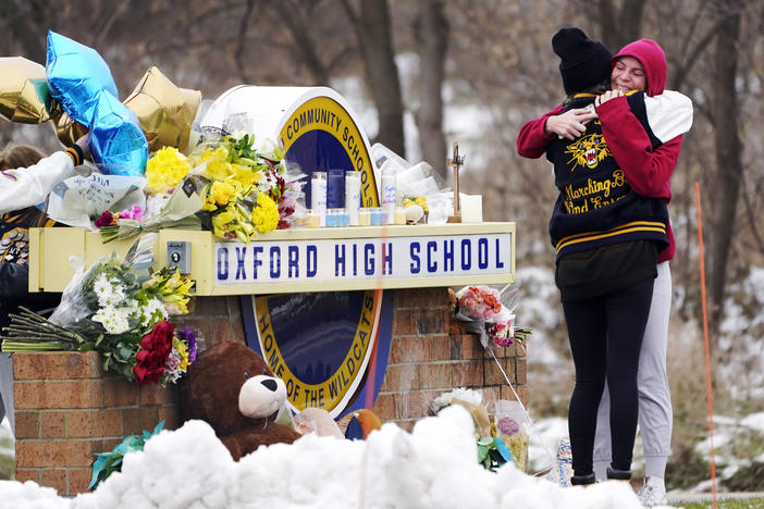 Students hug at a memorial at Oxford High School in Oxford, Mich., Dec. 1, 2021.