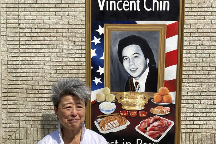 Activist and author Helen Zia stands next to a painting of Vincent Chin in Detroit. The city is partnering with The Vincent Chin 40th Remembrance & Rededication Coalition to honor civil rights efforts that began with Chin's killing in 1982.
