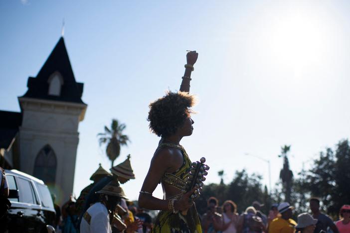 Prescylia Mae raises her fist in the air during a Juneteenth re-enactment celebration in Galveston, Texas, on June 19, 2021.