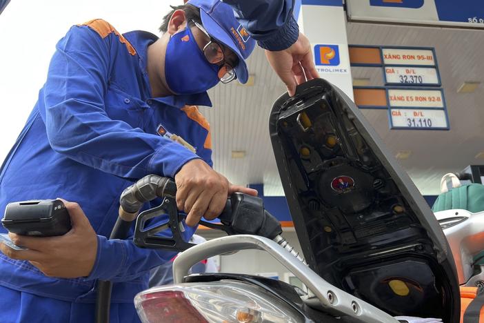 An attendant pumps gas into a motorcycle in Hanoi, Vietnam Sunday, June 19, 2022. Across the globe, drivers are rethinking their habits and personal finances amid skyrocketing prices for gasoline and diesel.