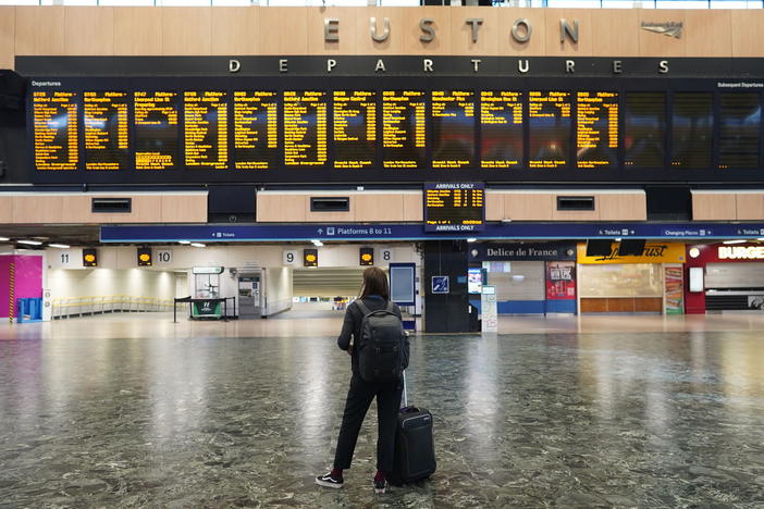 A passenger at Euston station in London looks at the departures board on the first day of a rail strike on Tuesday June 21, 2022.