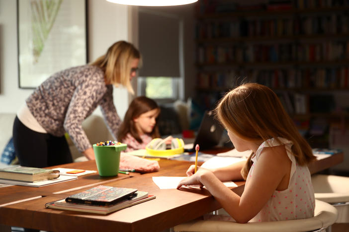Fourth-grader Lucy Kramer (foreground) does schoolwork at her home, as her mother, Daisley, helps her younger sister, Meg, who is in kindergarten, in 2020 in San Anselmo, Calif.