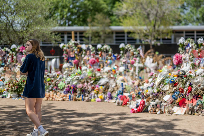 A young woman pays her respects at a memorial in front of Robb Elementary School earlier this monthin Uvalde, Texas. Committees have begun inviting testimony from law enforcement authorities, family members and witnesses regarding the mass shooting at Robb Elementary School which killed 19 children and two adults.