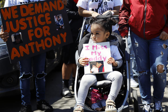 In this May 1, 2021, photo, Ailani Alvarez, 2, the daughter of Anthony Alvarez, who was shot by the police, holds a sign reading "I miss my daddy" during a protest in Chicago.