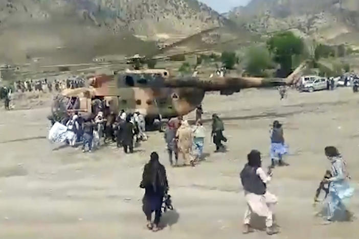 In this image taken from video from Bakhtar State News Agency, Taliban fighters secure a government helicopter to evacuate injured people in Gayan district, Paktika province, Afghanistan, Wednesday, June 22, 2022.