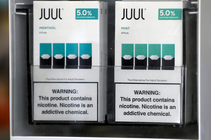 Packages of Juul mint-flavored e-cigarettes are displayed at a smoke shop in 2019.