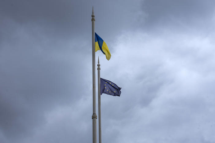 The Ukrainian (top) and European Union flags fly on poles in Kyiv on Thursday ahead of an EU summit in Brussels considering Ukraine's candidate status to join the 27-nation bloc.