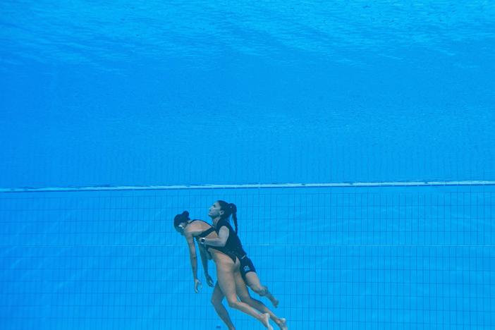 Team USA coach Andrea Fuentes brings Anita Alvarez from the bottom of the pool at the 2022 World Aquatics Championships in Budapest.