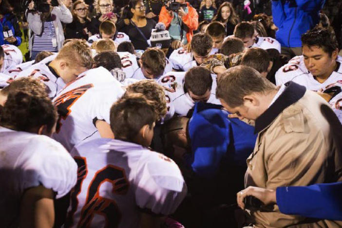 The parties included this image, of Coach Kennedy praying with a crowd after the homecoming game, in their joint appendix submitted to the Supreme Court