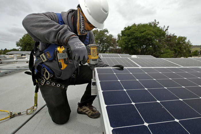 Gen Nashimoto, of Luminalt, installs solar panels in Hayward, Calif., on Wednesday, April 29, 2020.