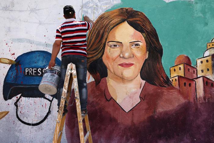 Palestinian artists paint a mural in honor of slain veteran Al Jazeera journalist Shireen Abu Akleh in Gaza City, after she was killed on May 11. A new U.N. report says Israeli forces fired the shots that killed Abu Akleh and injured a colleague.