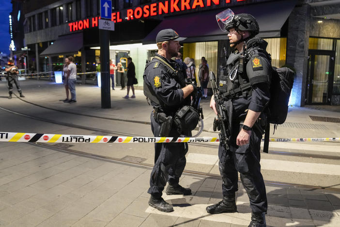 Police stand guard outside a bar in central Oslo, early Saturday. Norwegian police say two people have been killed and several injured in a mass shooting.