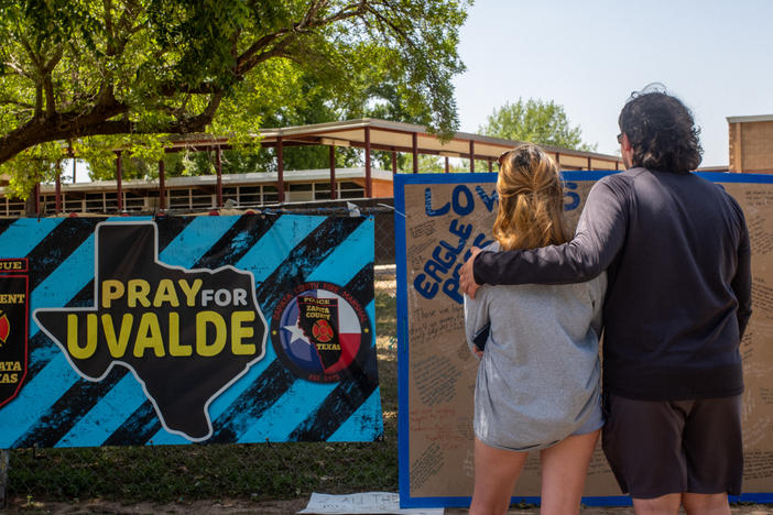 Siblings Kiley and Michael Regenthal pay their respects at a memorial in front of Robb Elementary School on June 17, in Uvalde, Texas.