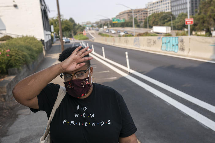 Katherine Morgan wipes sweat from her forehead while walking to work during a record-breaking heat wave in Portland in 2021. Scientists say that heat wave would have been virtually impossible without human caused climate change.