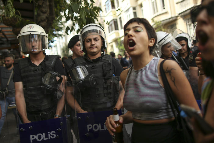 People shout slogans next to Turkish police officers during the LGBTQ Pride March in Istanbul, Turkey, Sunday, June 26, 2022.